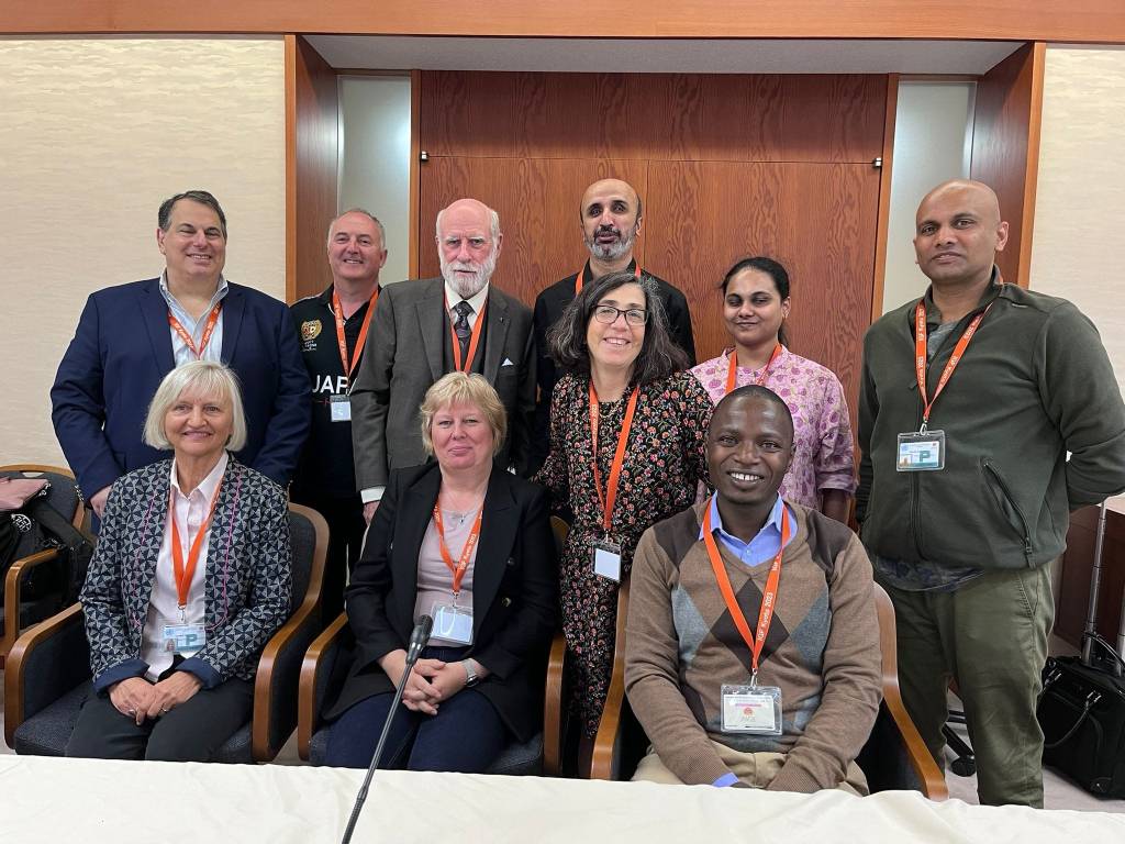 Group of people standing and sitting in front of camera